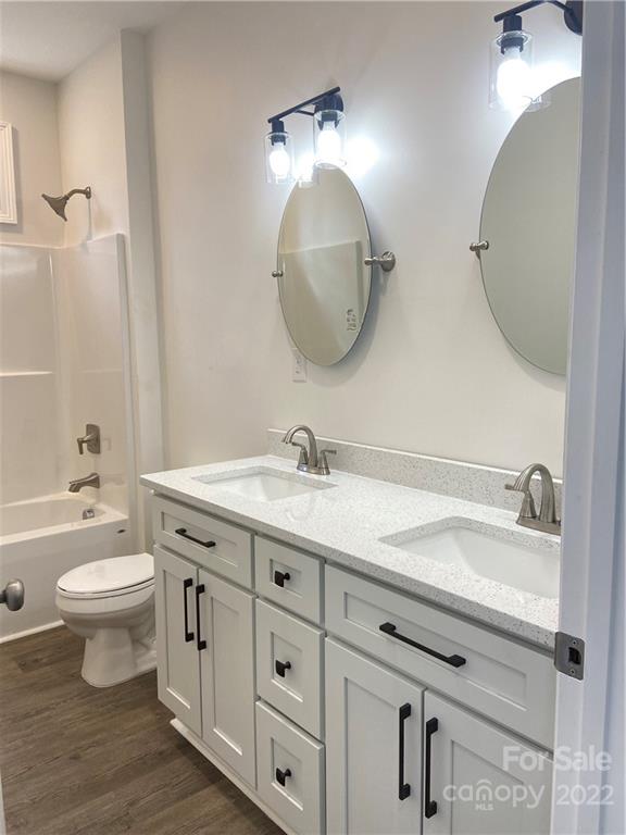 1208 Timber Spring Lane Salisbury, NC 28147 - Photo 17 of 19 a bathroom with a granite countertop toilet a sink and a mirror
