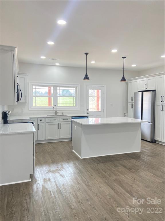 1208 Timber Spring Lane Salisbury, NC 28147 - Photo 10 of 19 a large kitchen with kitchen island a white counter space a sink a window and stainless steel appliances