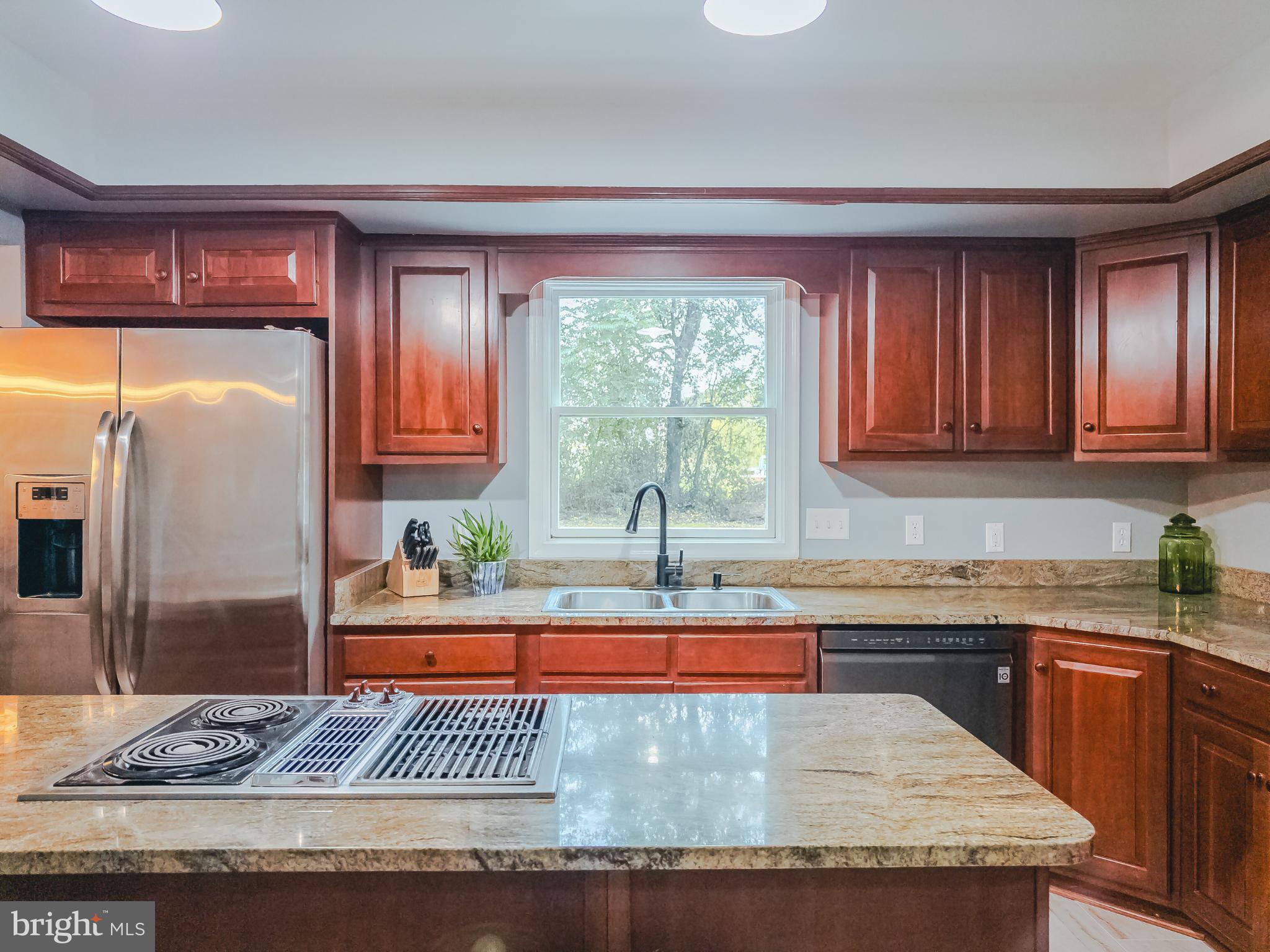 8749 Ramsburg Road Thurmont, MD 21788 - Photo 15 of 61 a kitchen with granite countertop a refrigerator a stove and a sink