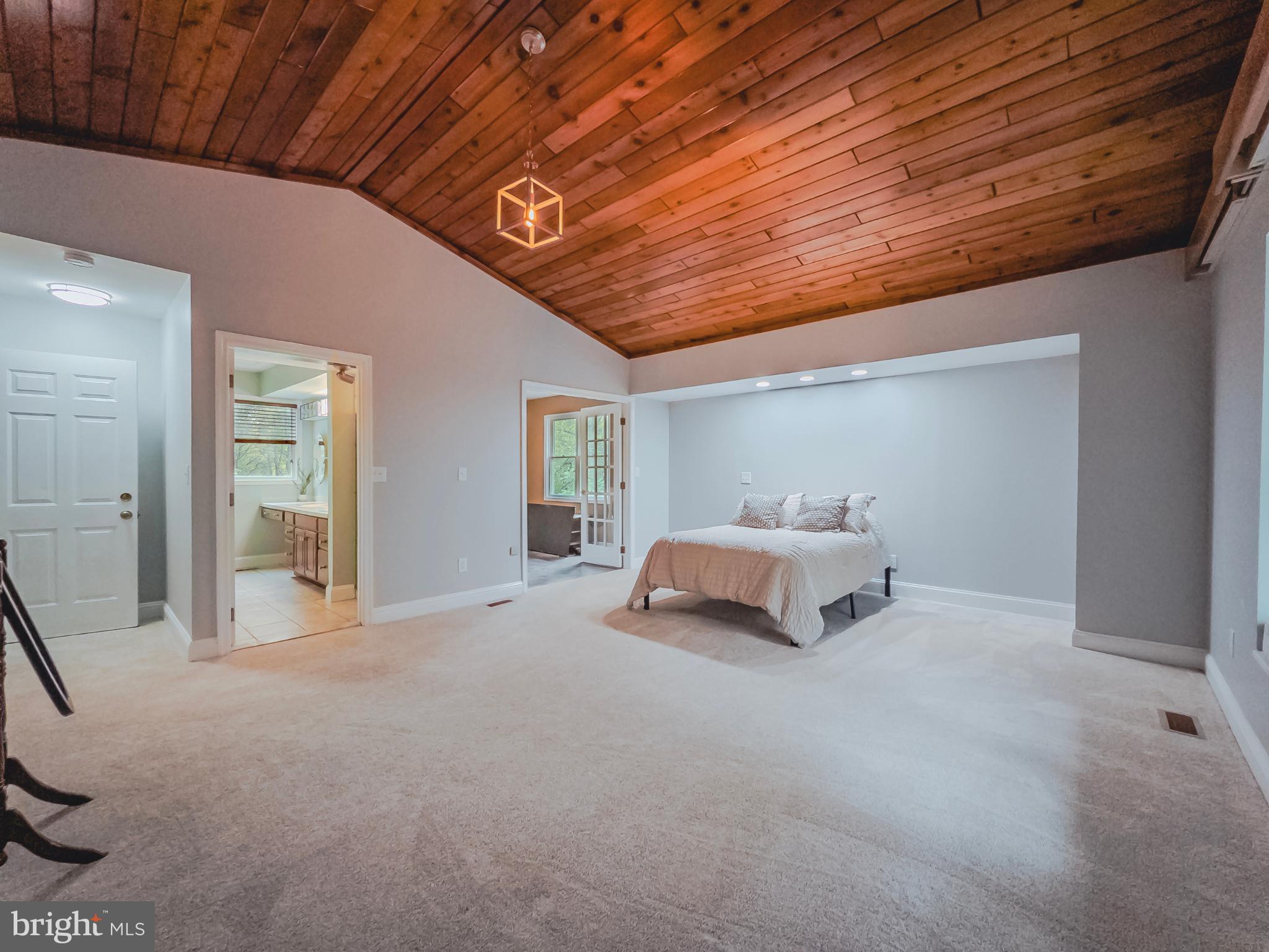 8749 Ramsburg Road Thurmont, MD 21788 - Photo 33 of 61 a spacious bedroom with a bed and a chandelier