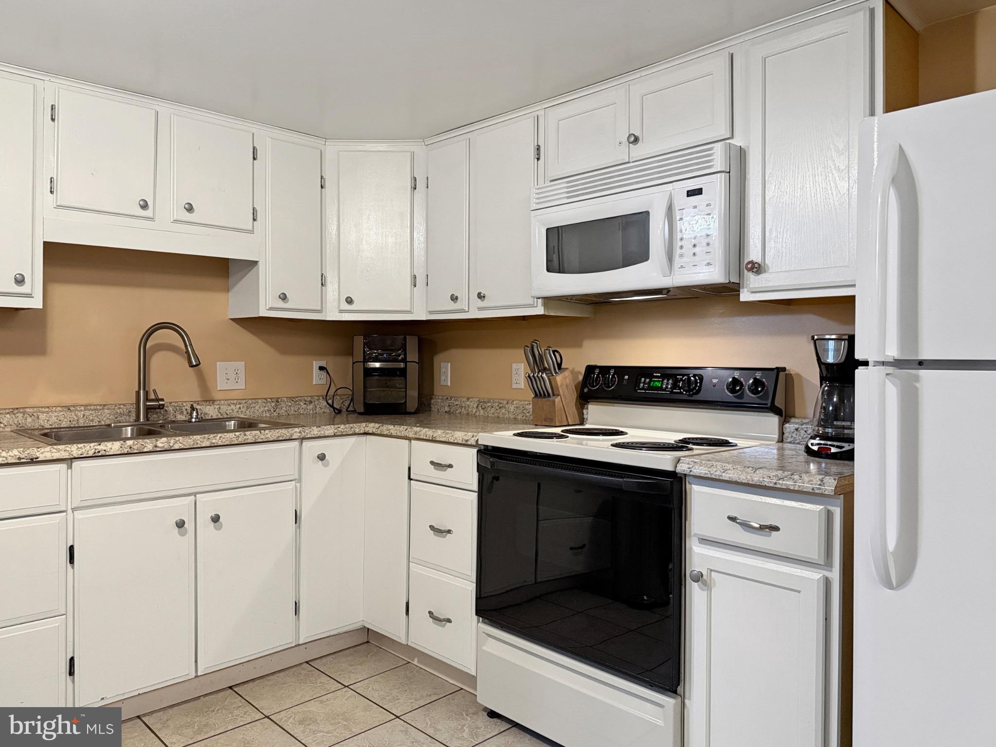 8749 Ramsburg Road Thurmont, MD 21788 - Photo 53 of 61 a kitchen with granite countertop white cabinets and white appliances