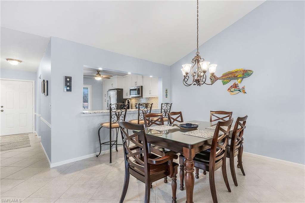 6780 Dennis Circle, Unit M206 Naples, FL 34104 - Photo 11 of 26 a view of a dining room with furniture and chandelier