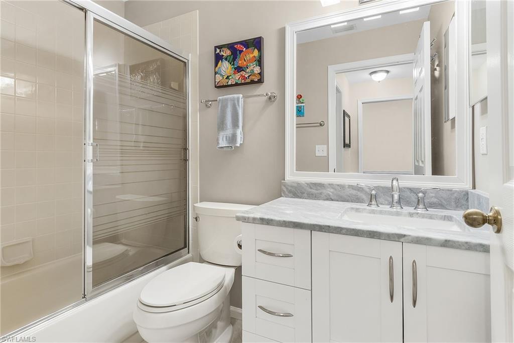 6780 Dennis Circle, Unit M206 Naples, FL 34104 - Photo 16 of 26 a bathroom with a granite countertop sink toilet and shower