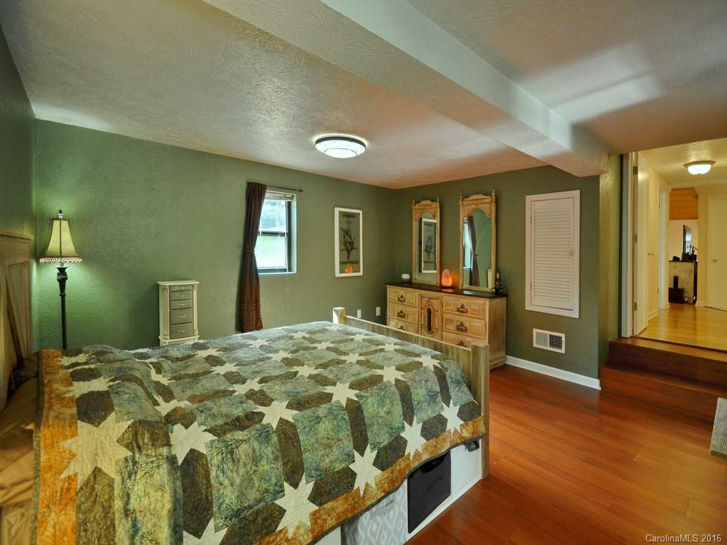 442 Thompson Cove Road Clyde, NC 28721 - Photo 12 of 20 a bedroom with a bed and a large mirror on dresser