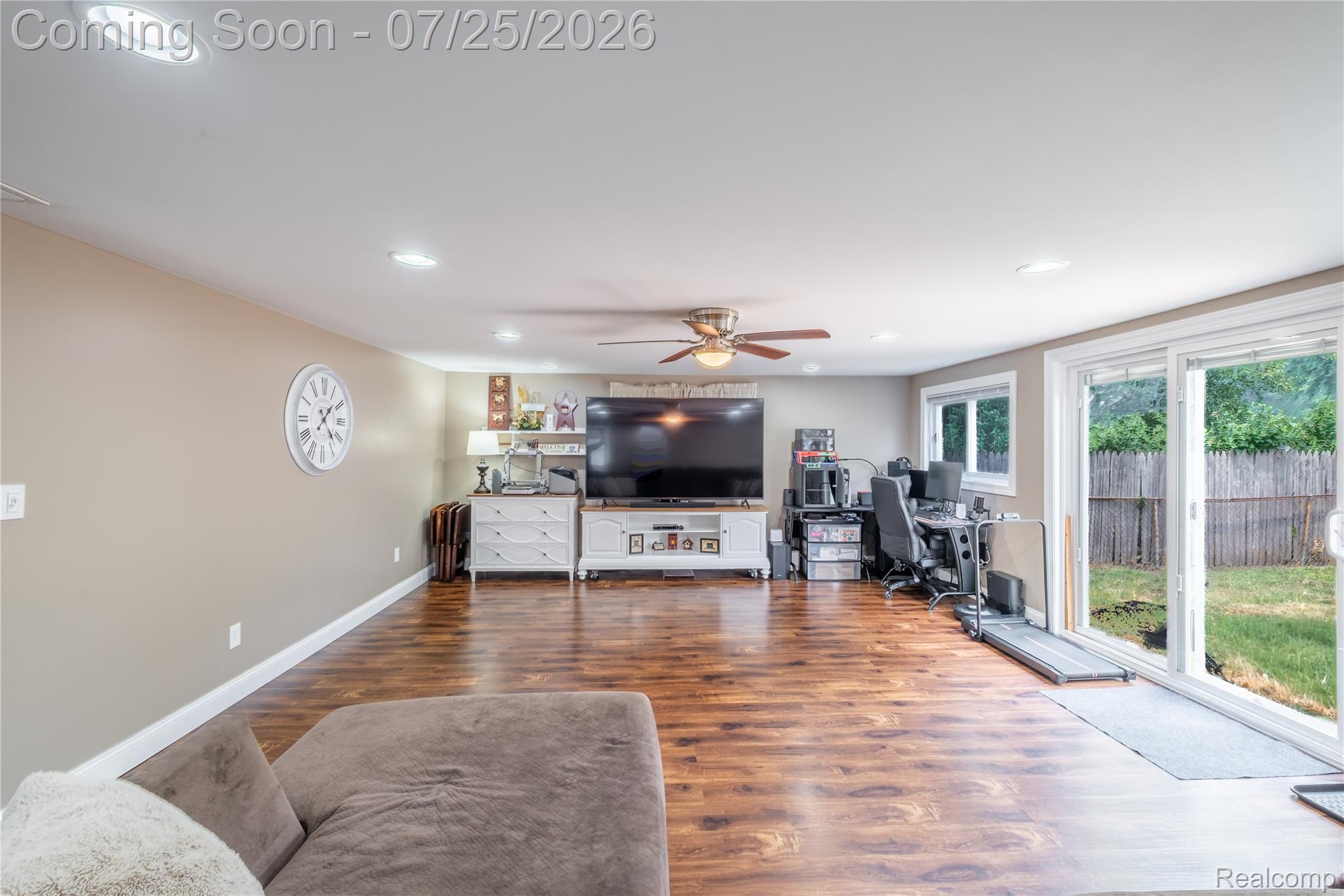 Spacious room featuring wood-finish flooring, recessed lighting, and a ceiling fan