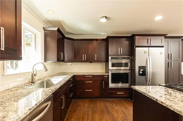 a kitchen with stainless steel appliances granite countertop a sink stove and refrigerator