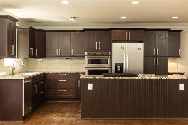 a kitchen with stainless steel appliances granite countertop a refrigerator and a stove