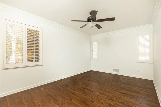 a view of a big room with wooden floor and windows