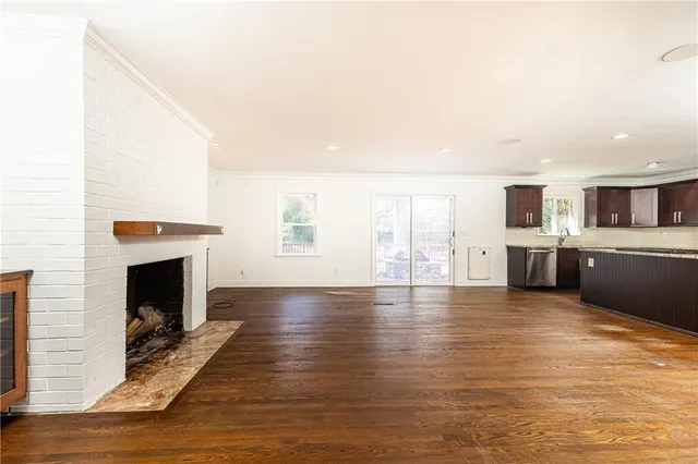a view of a livingroom with furniture a fireplace and wooden floor