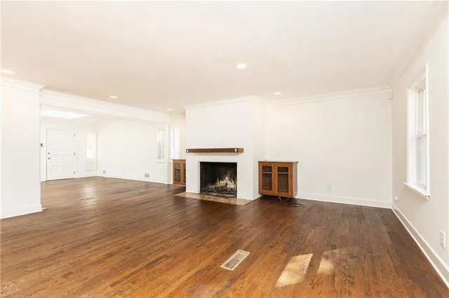 an empty room with wooden floor and fireplace