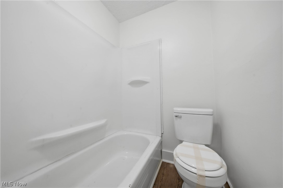 225 Cranz Place Akron, OH 44310 - Photo 17 of 34 Bathroom featuring bathing tub / shower combination, dark wood finished floors, and a textured ceiling