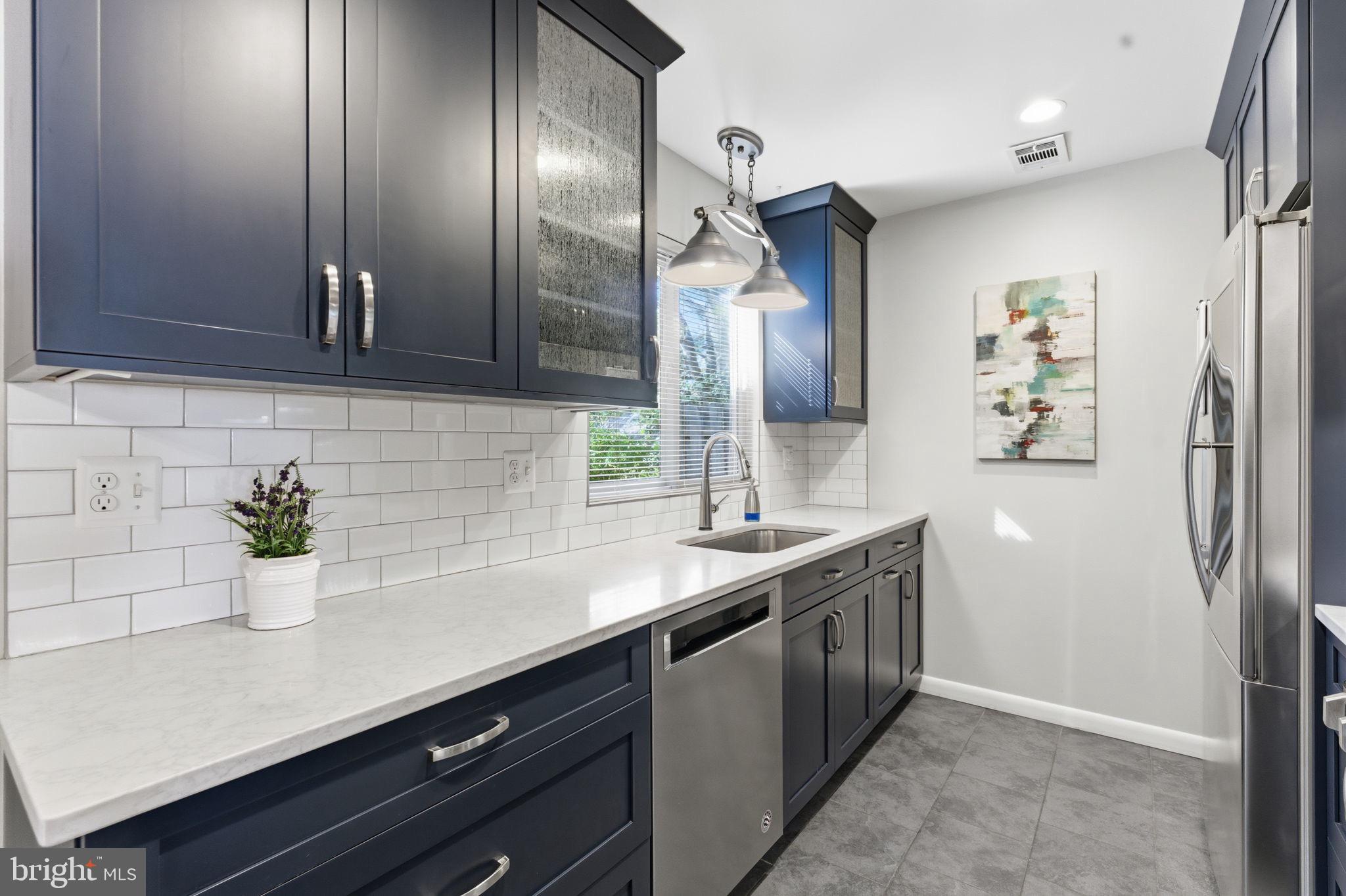11309 Gatesborough Lane Reston, VA 20191 - Photo 16 of 85 Sleek modern kitchen with navy cabinetry.