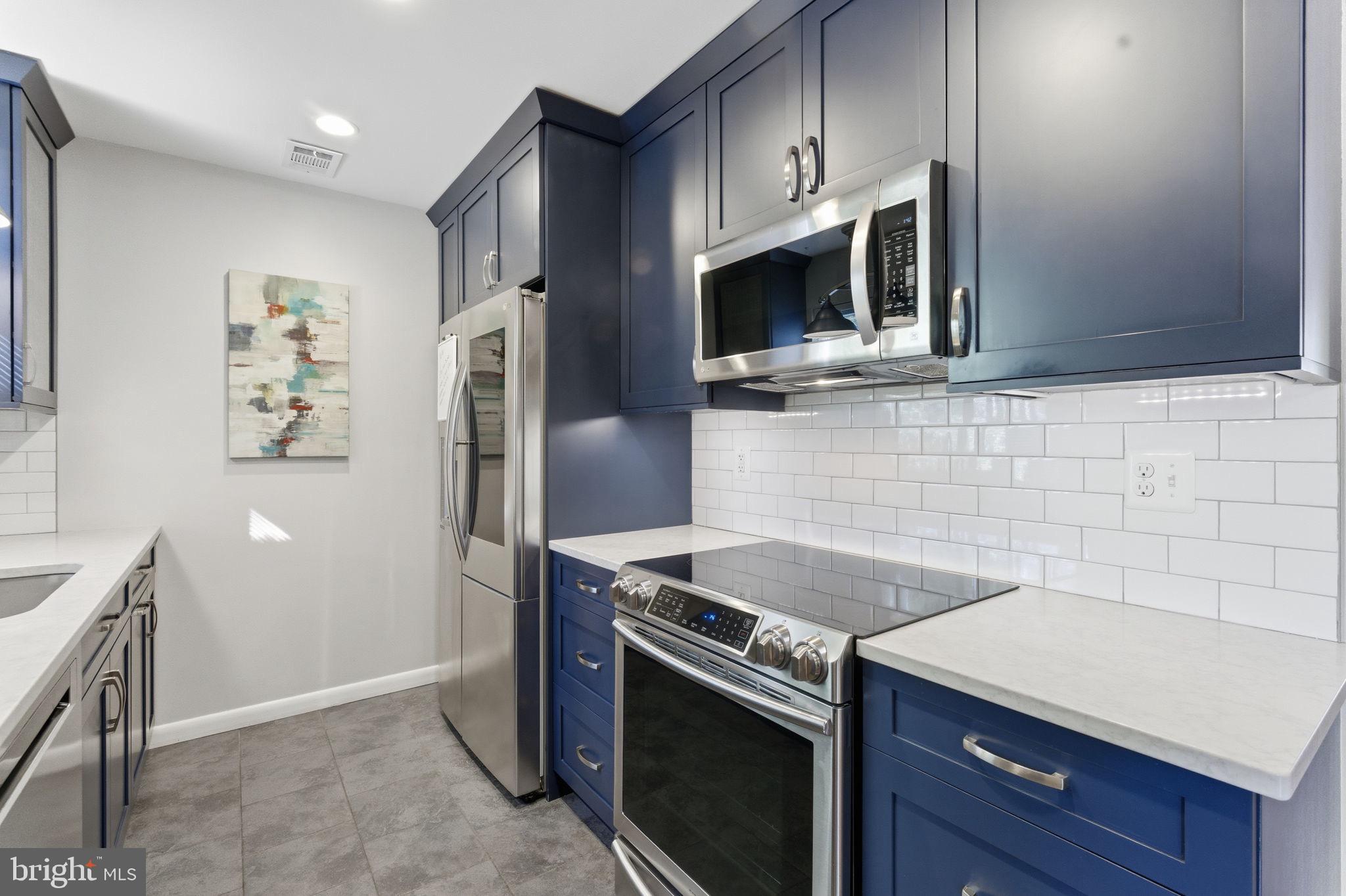 11309 Gatesborough Lane Reston, VA 20191 - Photo 17 of 85 a kitchen with stainless steel appliances granite countertop a stove a microwave and a refrigerator