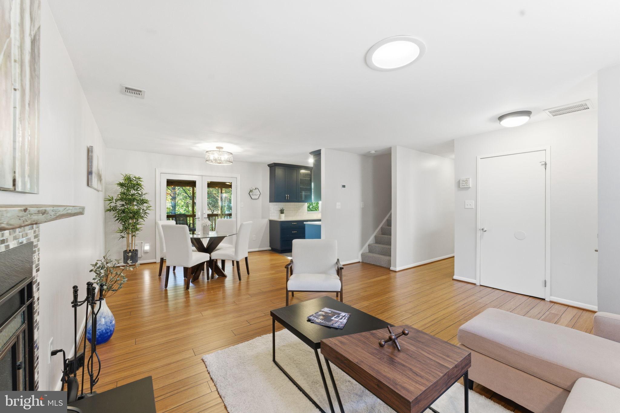 11309 Gatesborough Lane Reston, VA 20191 - Photo 9 of 85 a living room with furniture a rug and a dining table with kitchen view