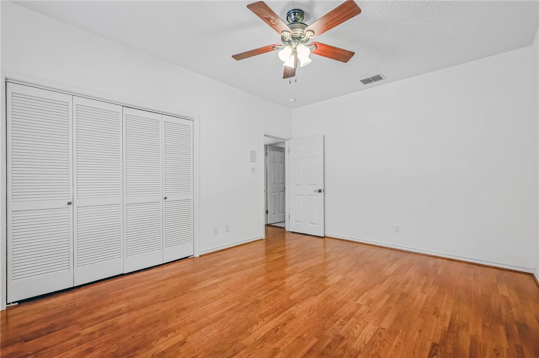 5917 Harvest Hill Road Corpus Christi, TX 78414 - Photo 35 of 40 an empty room with wooden floor chandelier fan and windows