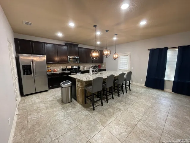 a kitchen with a sink and chairs