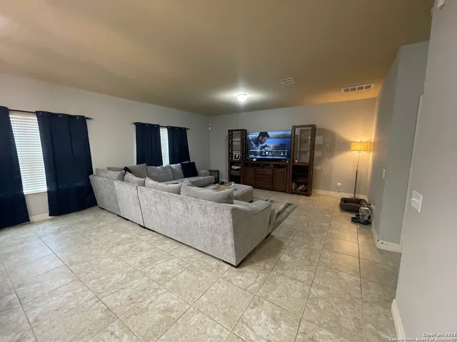 a living room with furniture and a dining table with kitchen view