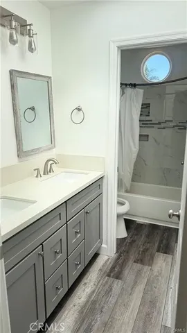 a spacious bathroom with a double vanity sink a toilet and a mirror