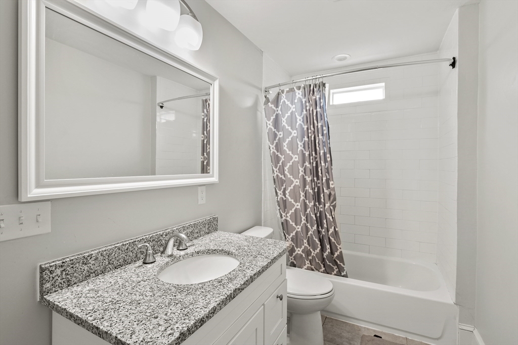 139 Adams Street, Unit 3 Waltham, MA 02453 - Photo 16 of 17 a bathroom with a granite countertop sink toilet and shower