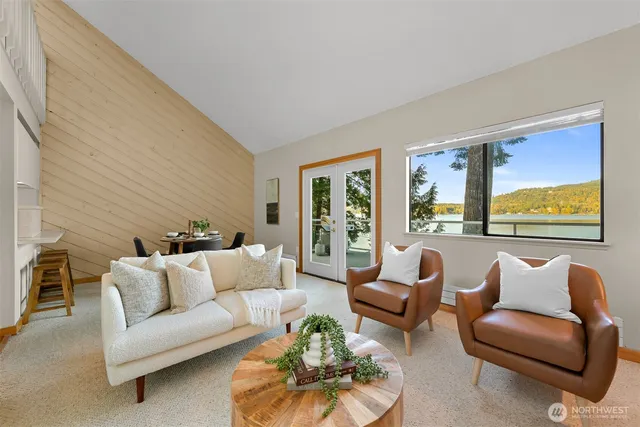 a living room with furniture potted plant and a large window