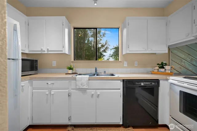 a view of staircase with lots of frames on wall and a window
