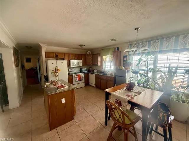 a kitchen with stainless steel appliances kitchen island granite countertop a refrigerator and a stove top oven