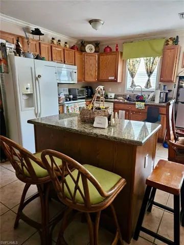 a kitchen with stainless steel appliances kitchen island a table chairs in it and wooden floors