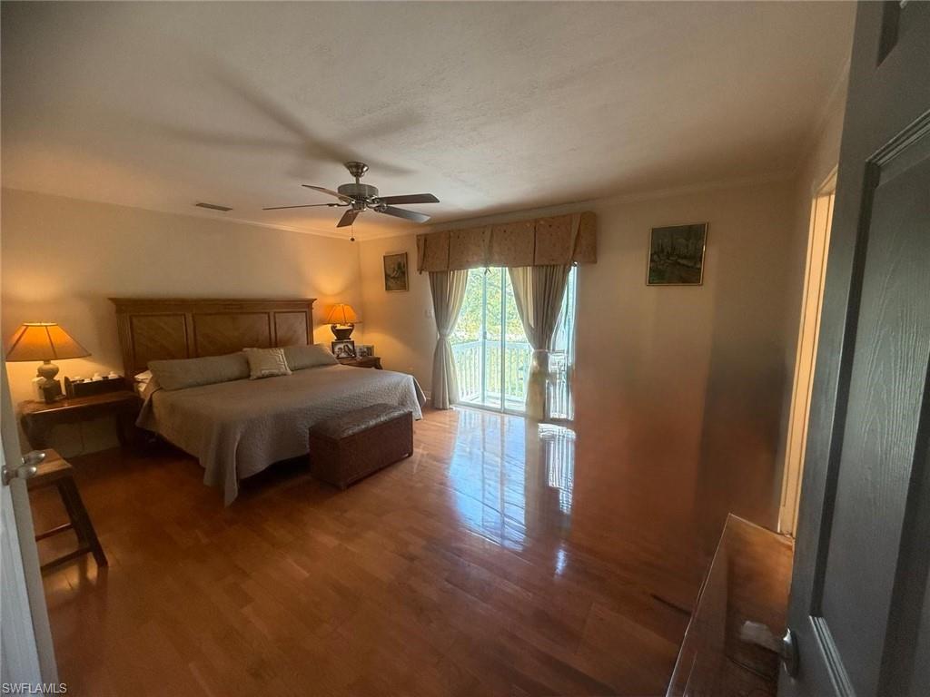 199 Leawood Circle Naples, FL 34104 - Photo 20 of 21 a bedroom with a bed and wooden floor