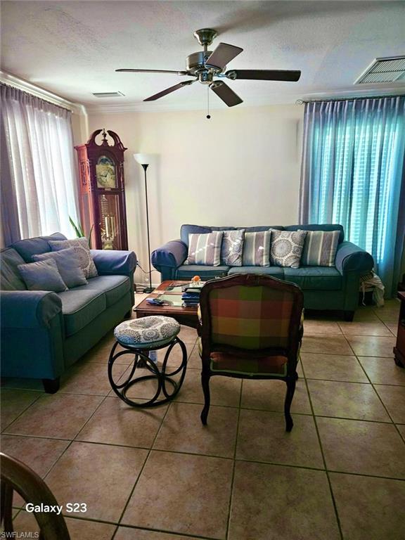 199 Leawood Circle Naples, FL 34104 - Photo 8 of 21 a living room with furniture and a chandelier