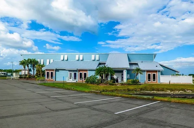 a front view of a house with a garden and lake view