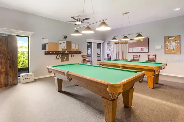 a room with pool table and windows