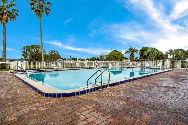 a view of a swimming pool with a patio and a yard