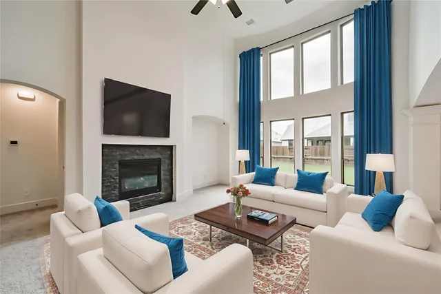 a living room with furniture fireplace and a large window