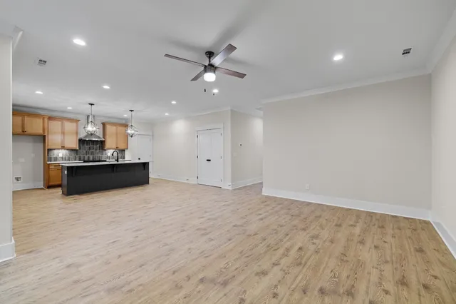 a kitchen with stainless steel appliances granite countertop a refrigerator a stove and a wooden floors