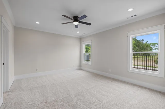 en empty room with windows and ceiling fan