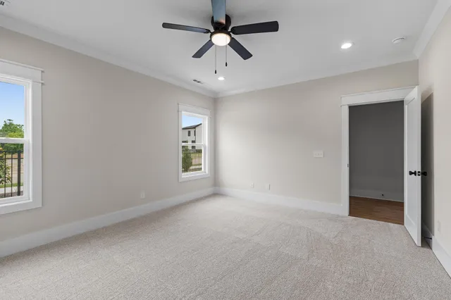 an empty room with ceiling fan and window