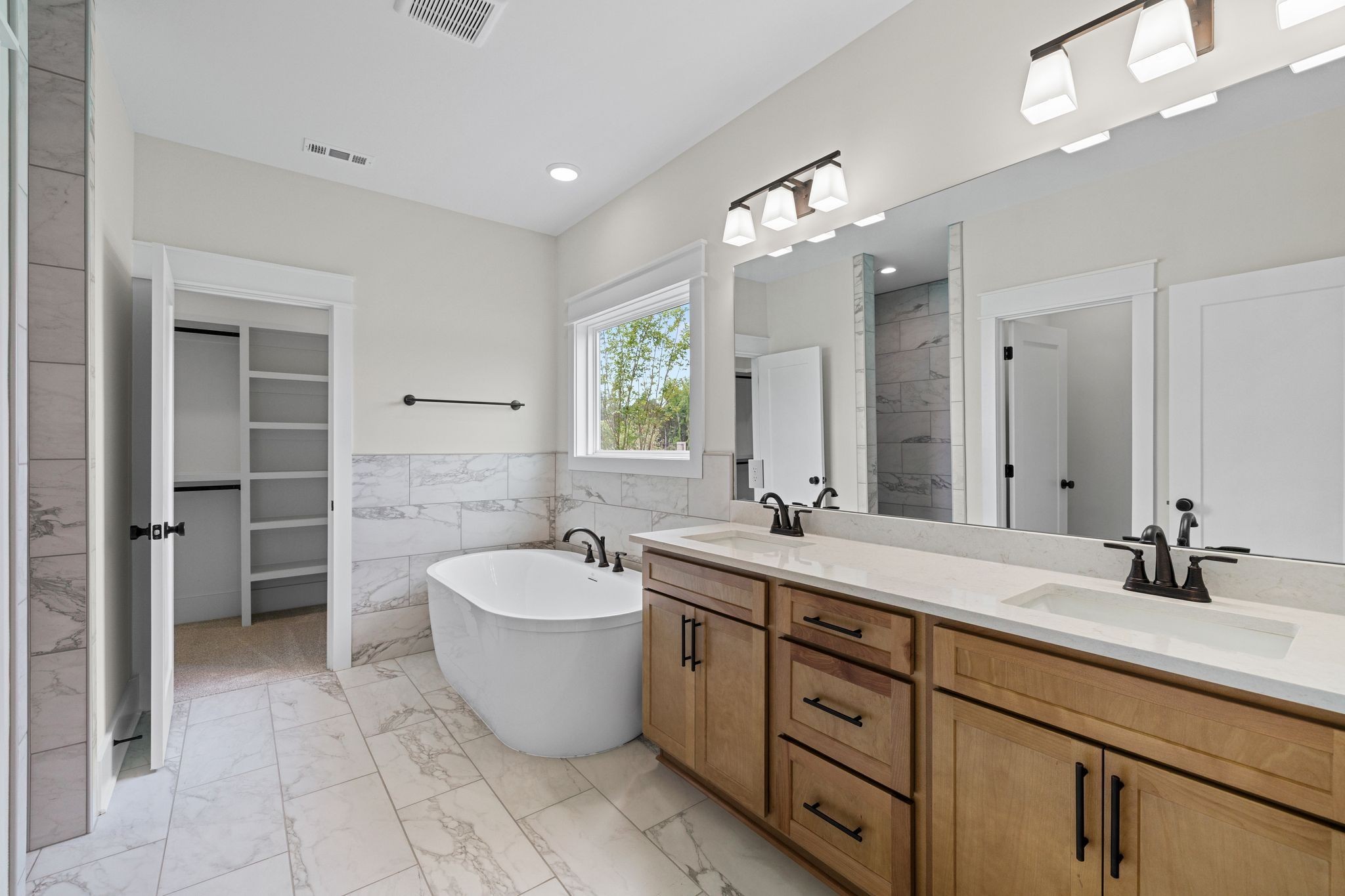 2039 Grace Johns Circle Murfreesboro, TN 37128 - Photo 3 of 33 a bathroom with a double vanity sink a toilet a mirror and bathtub