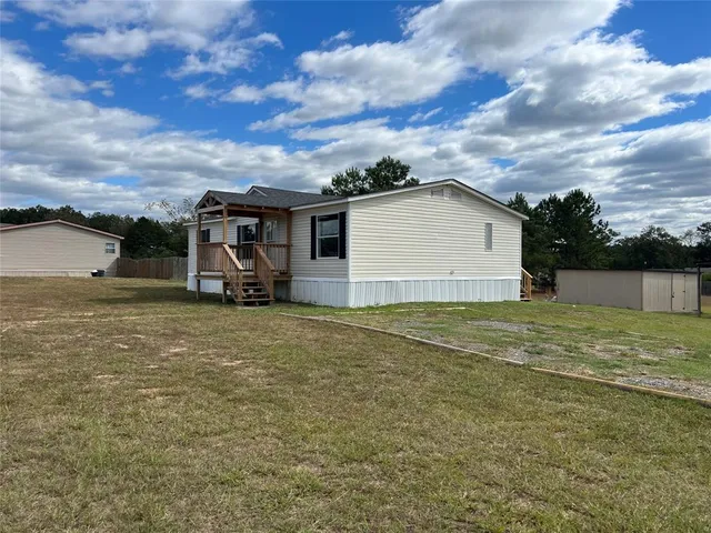 a view of a house with a yard and sitting area