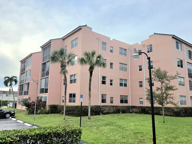 a view of a tall building next to a yard