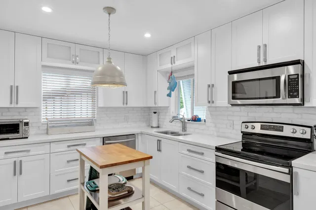 a kitchen with stainless steel appliances a stove sink microwave and cabinets