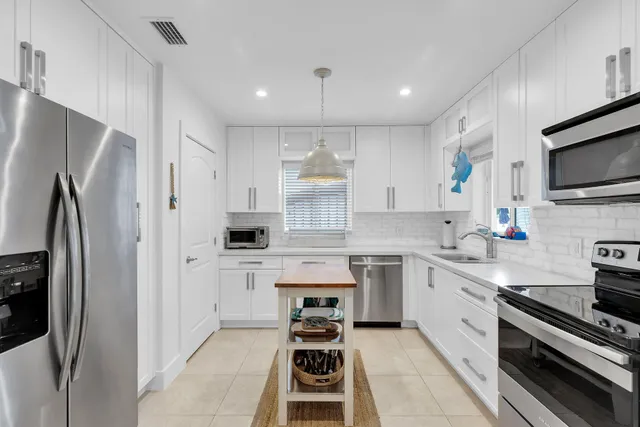 a kitchen with stainless steel appliances a stove sink and refrigerator