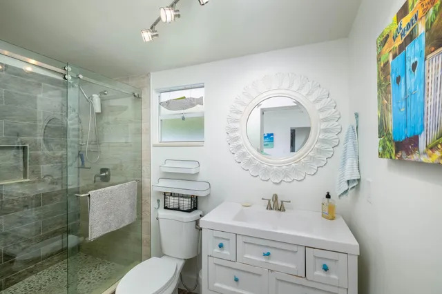 a bathroom with a sink a toilet and shower