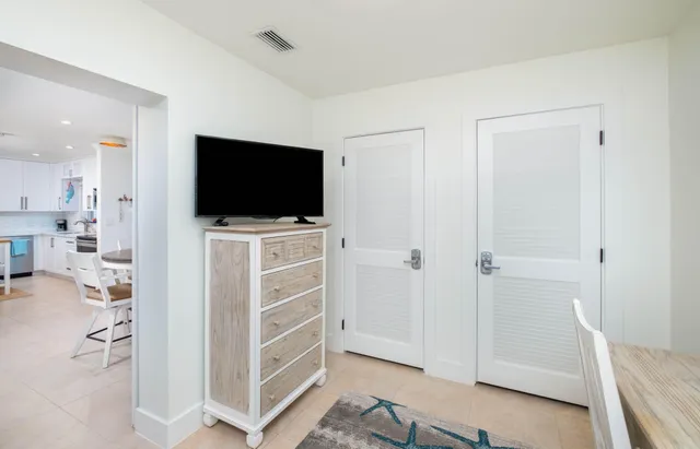 a view of a livingroom with wooden floor and a flat screen tv