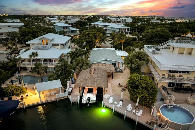 an aerial view of a house with a garden and lake view