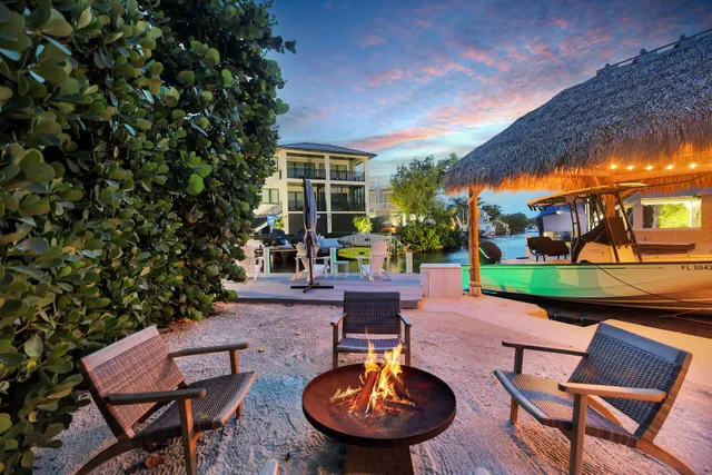 a view of a lake with a table and chairs under an umbrella