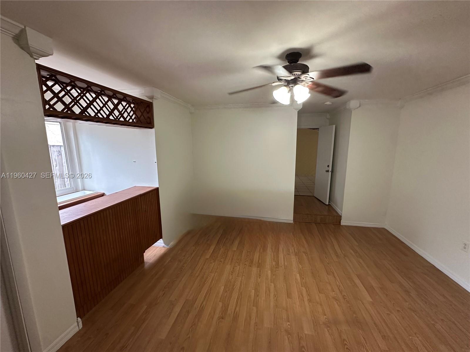 11600 Southwest 113th Place Miami, FL 33176 - Photo 18 of 21 a view of an empty room with wooden floor and a ceiling fan