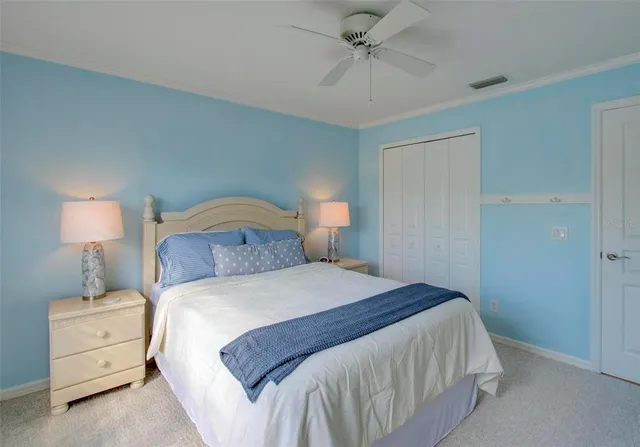 a bedroom with a bed and a lamp on the dresser