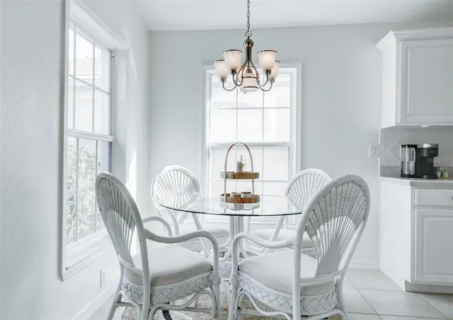 a dining room with furniture a chandelier and window