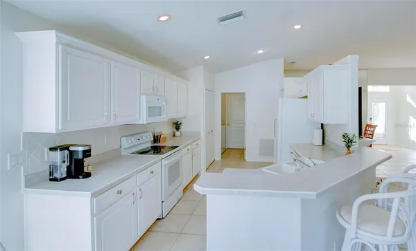 a kitchen with white cabinets and sink