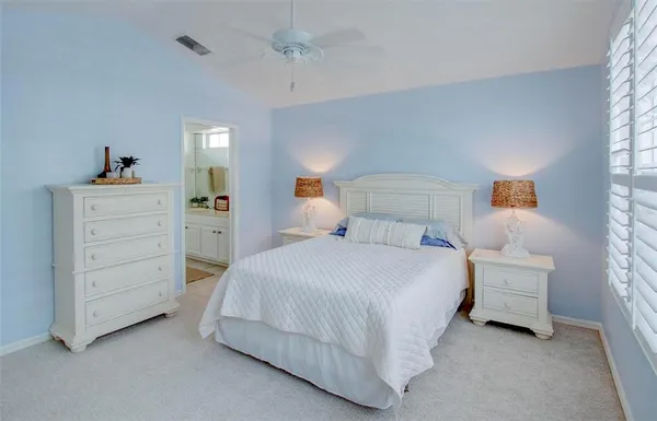 a bedroom with a bed a chandelier and window